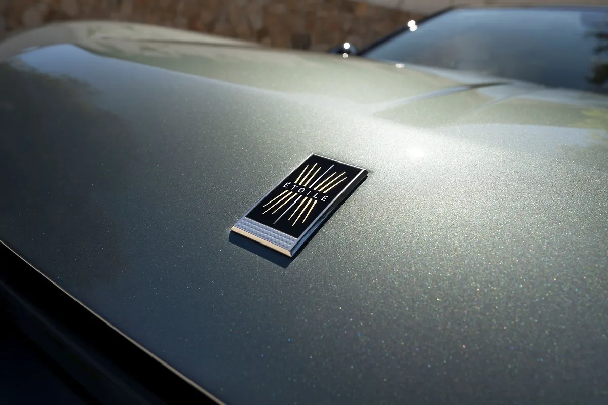 Nahaufnahme der graugrünen Motorhaube eines DS N°7 mit rechteckigem Emblem.