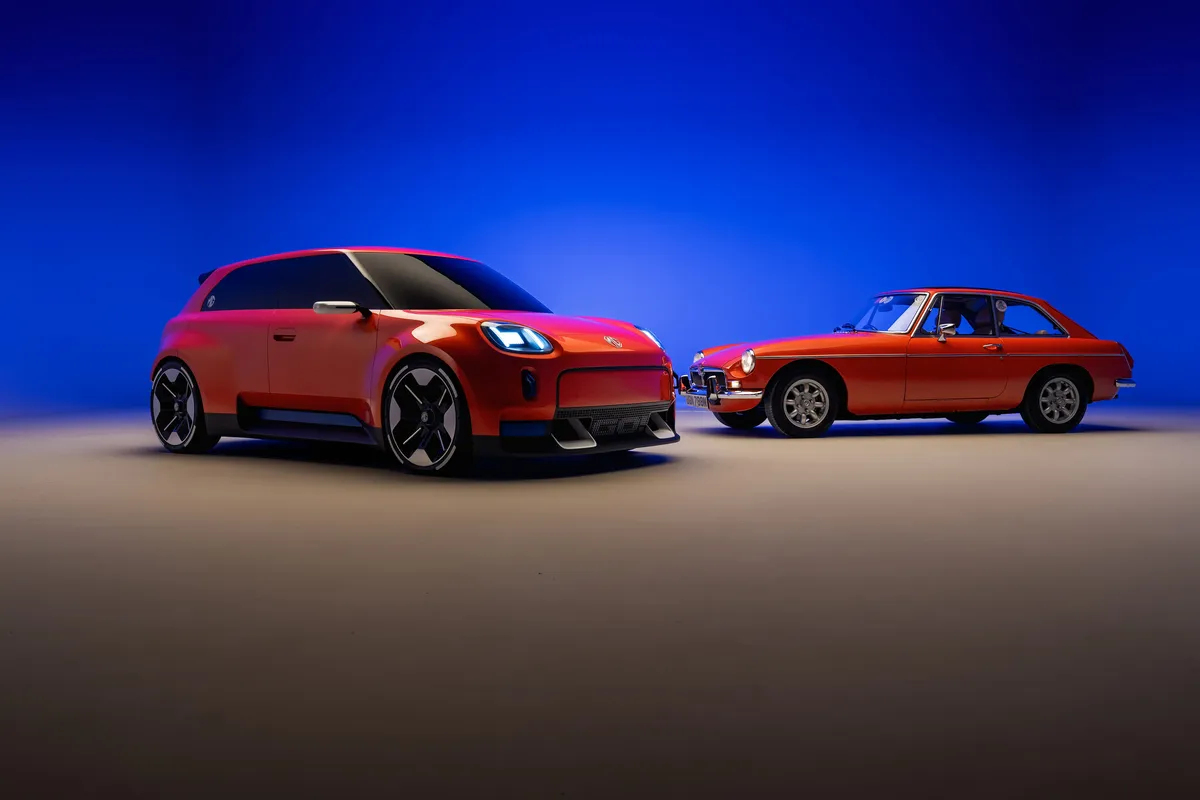 Oranges MG GO! Concept von schräg vorne neben einem klassischen orangeroten MGB GT im Seitenprofil vor blauem Studiohintergrund.