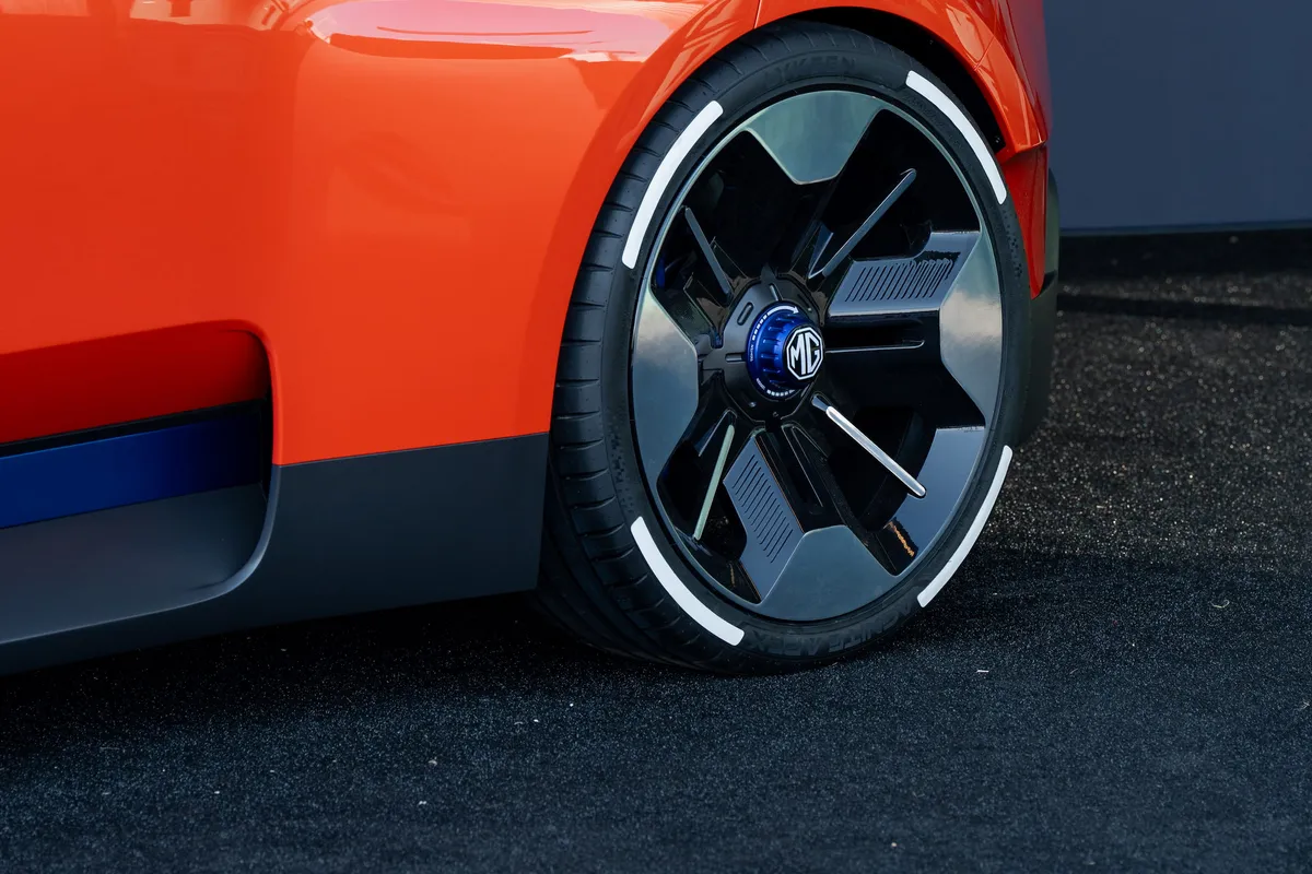 Nahaufnahme des Vorderrads und der blau-grauen Seitenleiste des orangen MG GO! Concept.