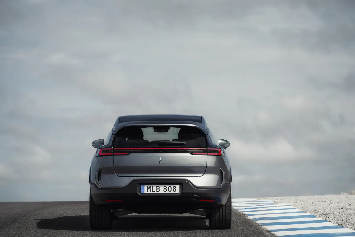 Grauer Polestar 3 direkt von hinten mit durchgehendem Leuchtenband auf einer Teststrecke.