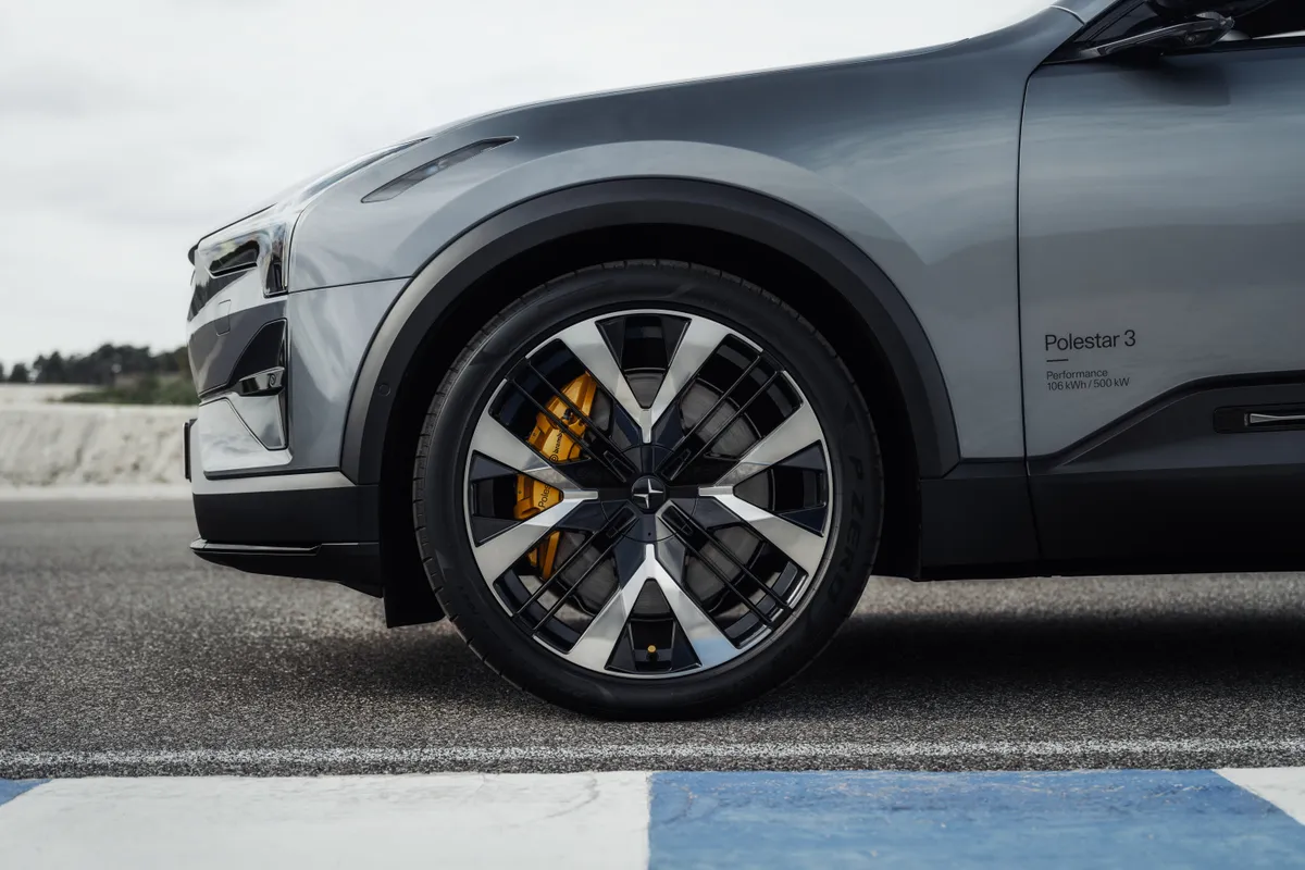 Vorderrad eines grauen Polestar 3 mit schwarz-silberner Felge und gelbem Bremssattel.