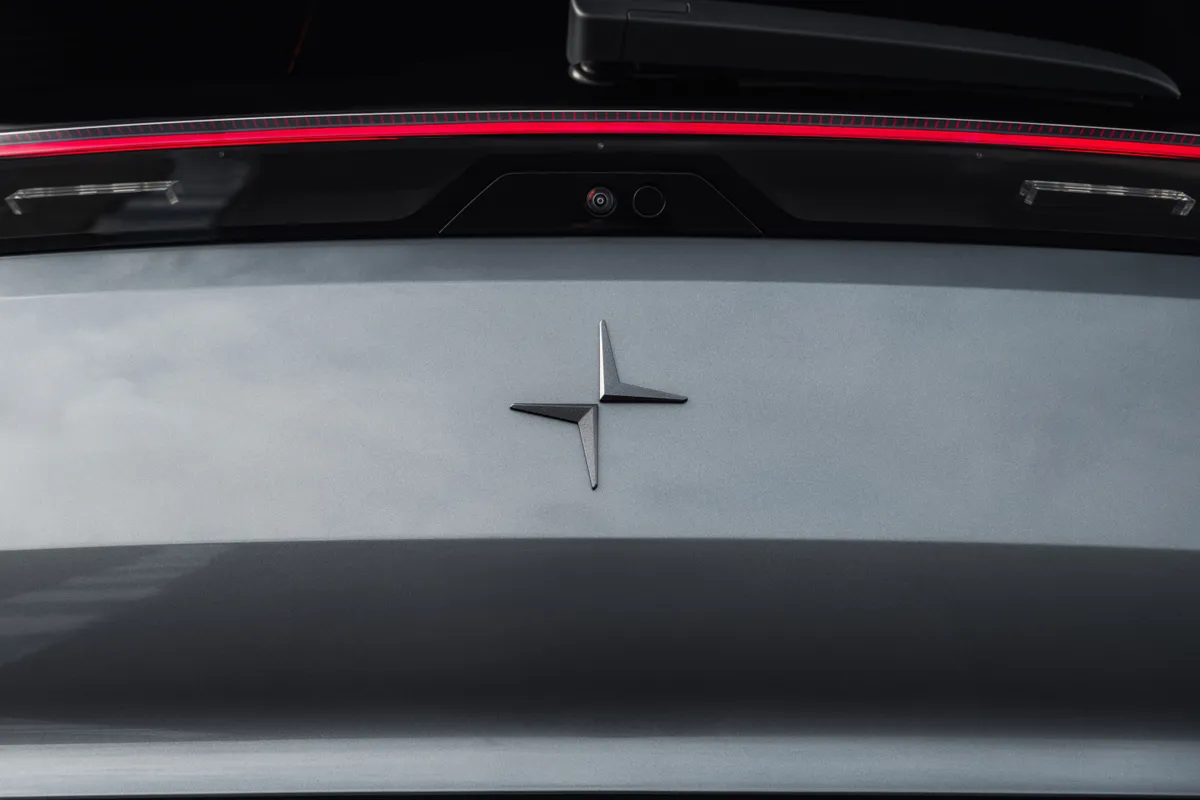 Heck eines grauen Polestar 3 mit schwarzem Polestar-Emblem unter dem roten Leuchtenband.