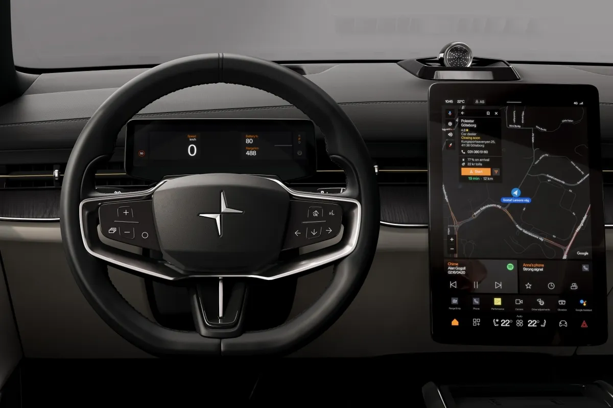 Frontaler Blick ins schwarze Cockpit des Polestar 3 mit Lenkrad, Fahrerdisplay und Navigationskarte auf dem Mittelbildschirm.