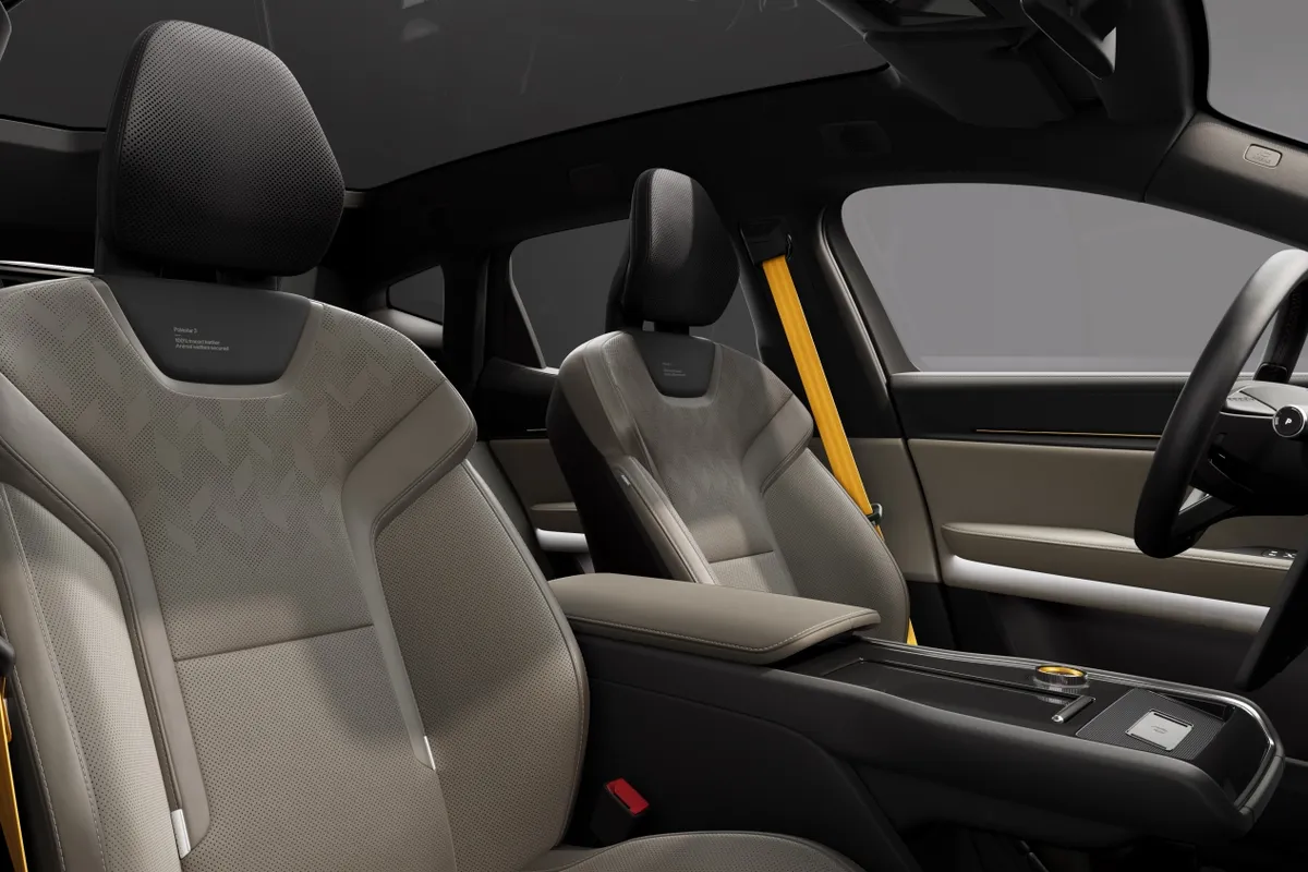 Hellgraue Vordersitze eines Polestar 3 mit schwarzen Kopfstützen und gelbem Sicherheitsgurt.