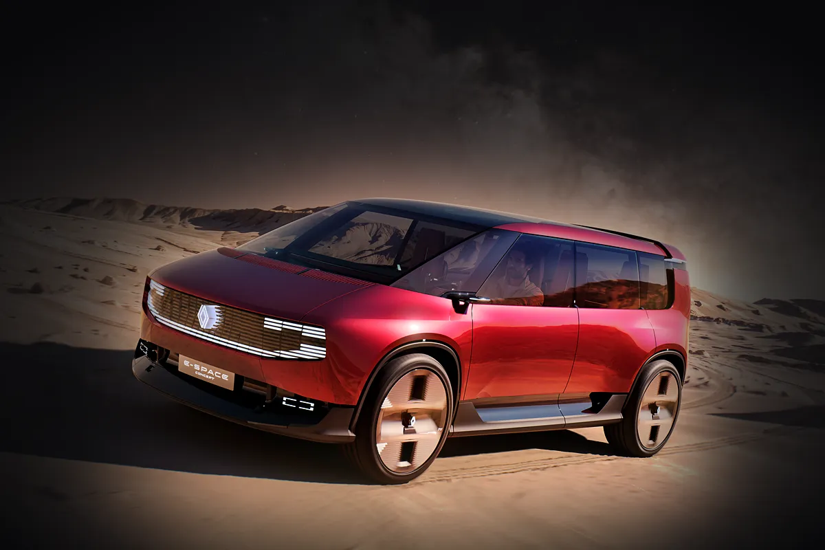 Rotes Renault E-Space Concept von schräg vorne in einer felsigen Wüstenlandschaft unter dunklem Himmel, die Umgebung abgedunkelt, die Studie hell beleuchtet.