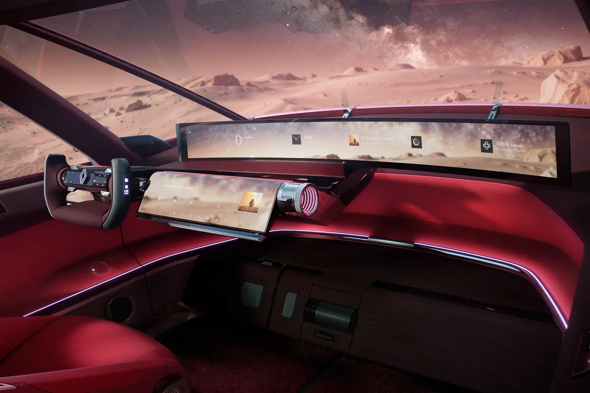 Cockpit des E-Space Concept mit kompaktem Lenkrad, breitem Panorama-Display über die ganze Armaturentafel und zweitem Bildschirm darunter; durch die Frontscheibe ist eine Felslandschaft zu sehen.