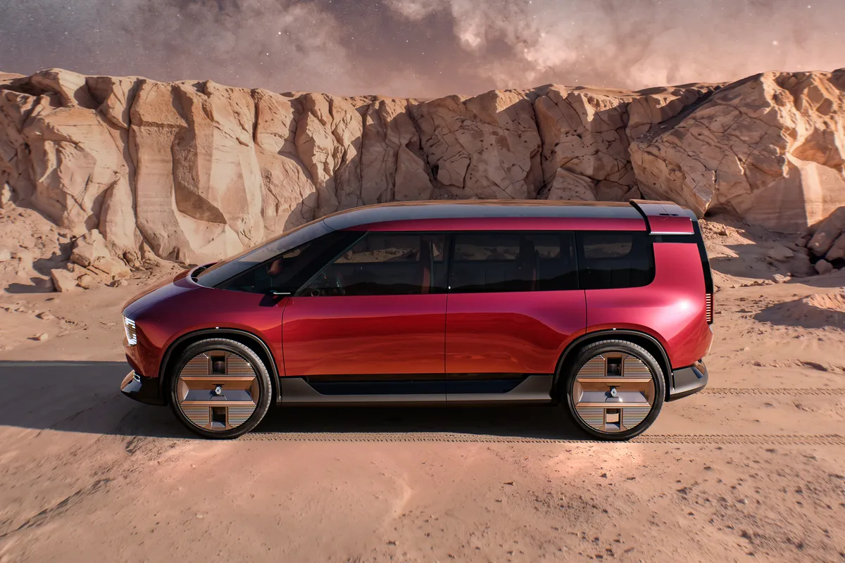 Rotes Renault E-Space Concept in der Seitenansicht auf hellem Sand vor hohen Felswänden.