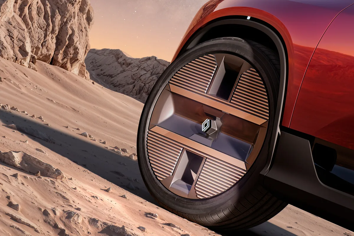 Nahaufnahme eines geometrisch gestalteten Rads des E-Space Concept im Sand.