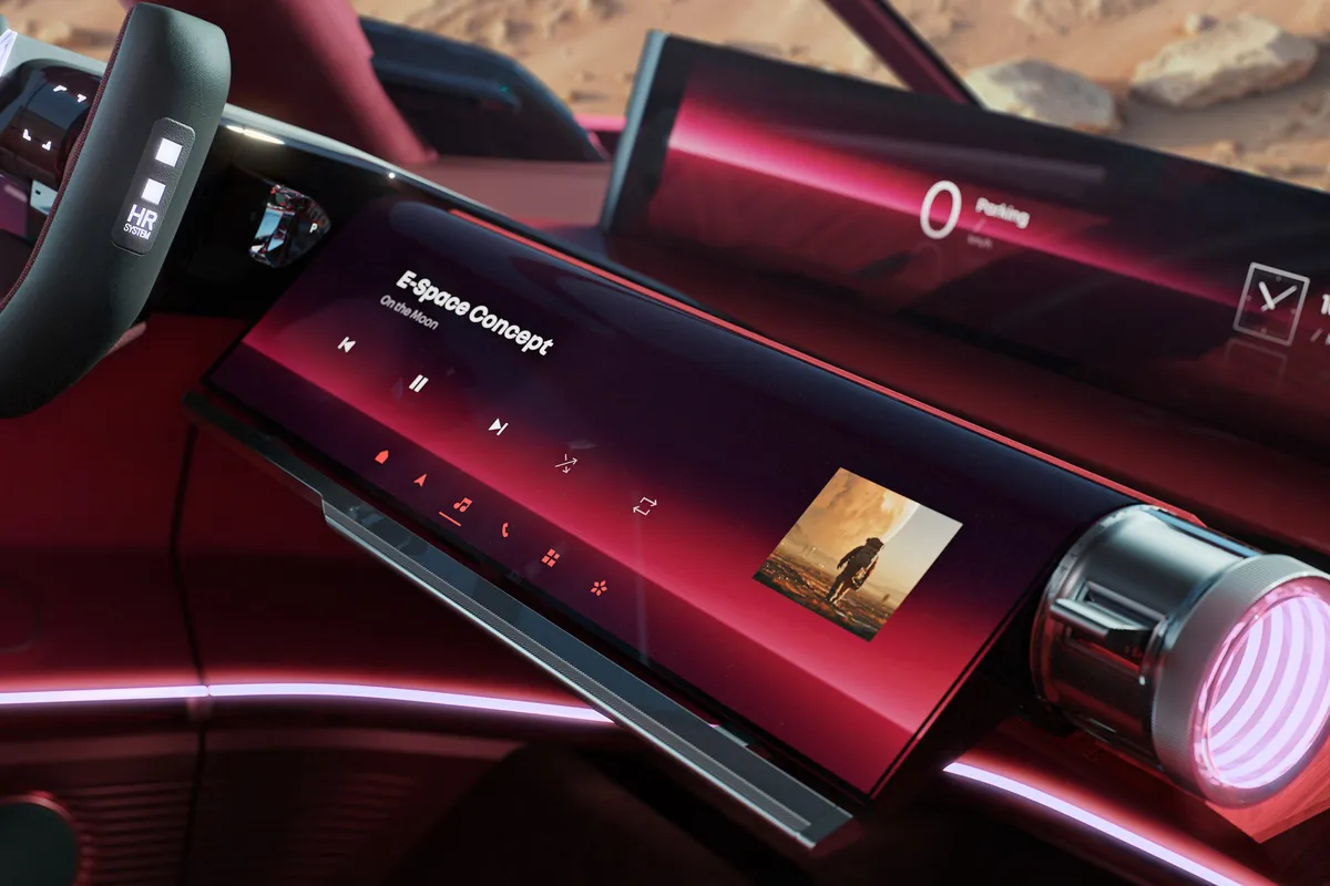Lenkrad des E-Space Concept vor dem breiten Display, daneben ein zylindrischer Träger mit Bedienelementen.