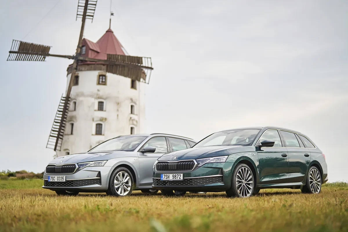 Ein dunkelgrüner und ein silberner Škoda Octavia Combi der vierten Generation auf einer Wiese vor einer Windmühle.