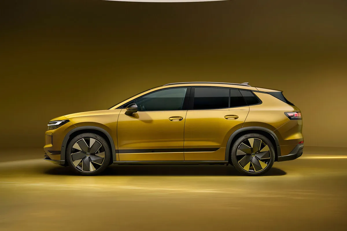Goldfarbener VW ID. Tiguan in der Seitenansicht vor goldbraunem Studiohintergrund.