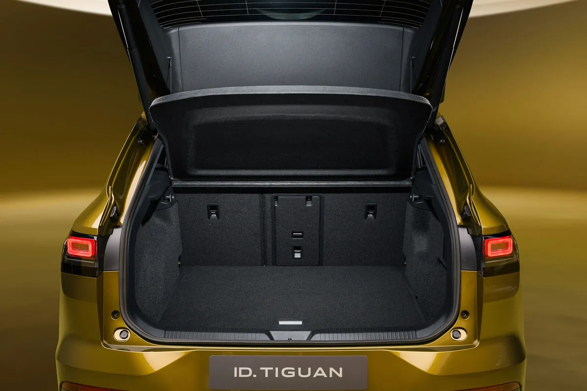 Geöffneter Kofferraum des goldfarbenen VW ID. Tiguan mit aufrechter Rücksitzbank und angehobener Hutablage.