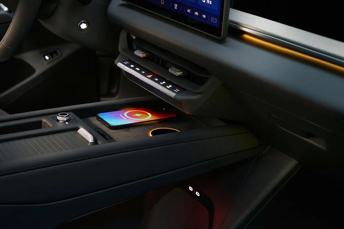 Mittelkonsole des VW ID. Tiguan mit einem Smartphone auf der Ladefläche, einem Drehregler und Ablagen.