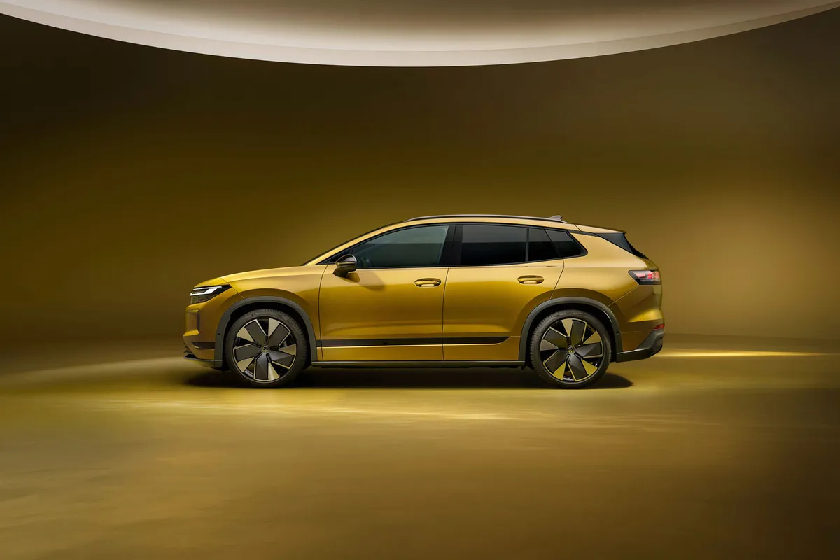 Seitenansicht des goldfarbenen VW ID. Tiguan mit dunklem Dach und Dachreling.