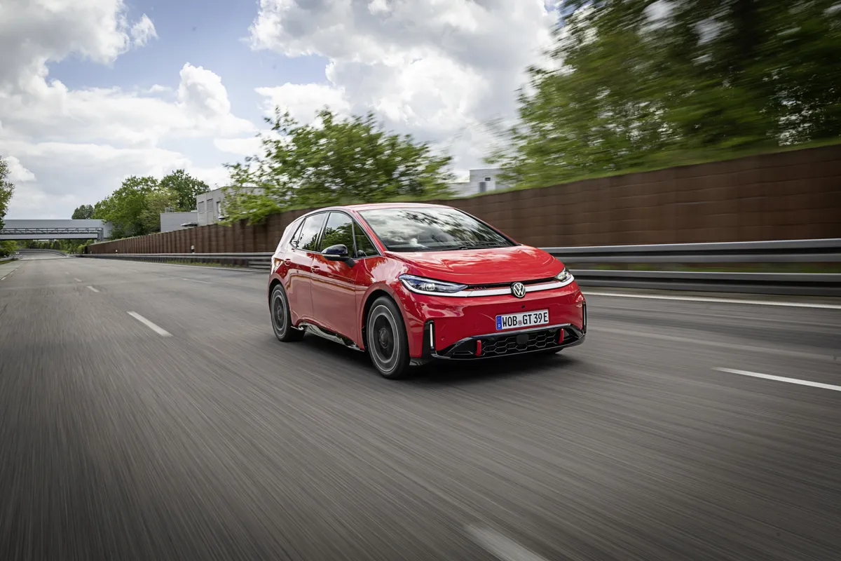 Roter VW ID.3 GTI fährt von schräg vorne auf einer mehrspurigen Straße neben Leitplanke und Lärmschutzwand.