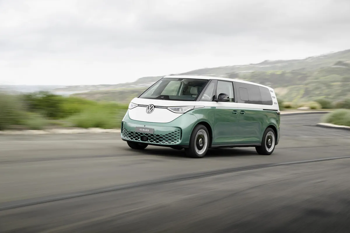 Mintgrün-weißer VW ID. Buzz mit langem Radstand von schräg vorne auf einer Landstraße.